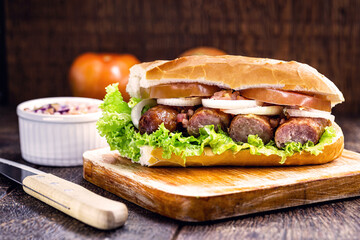 traditional Brazilian sandwich of bread with sausage, tomato, onion and lettuce. Crispy salt bread with roasted or fried sausage.