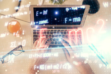 Double exposure of man's hands typing over computer keyboard and formula hologram drawing. Top view. Education concept.