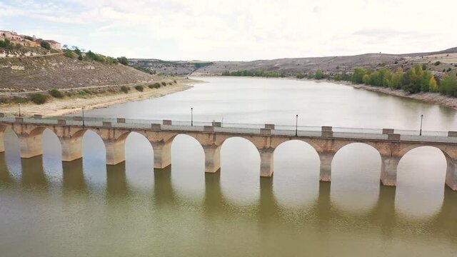 (aerial forward dolly movement) bridge over Riaza river, embalse de Linares reservoir in Maderuelo, province of Segovia, Castilla Leon, Spain