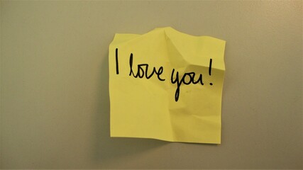 Crumbled handwritten note "I love you" on a white surface 