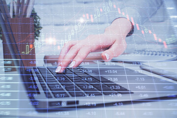 Multi exposure of woman hands typing on computer and forex chart hologram drawing. Stock market analysis concept.