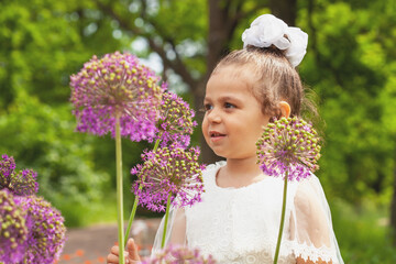 A little girl in a white dress of the bride in nature.