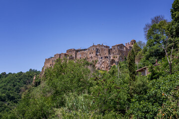 Fototapeta na wymiar Calcata, small medieval village, Italy. Panoramic view of the village of Calcata, in the province of Viterbo, Italy. Medieval village built entirely of tuff and immersed in the green of the forest.