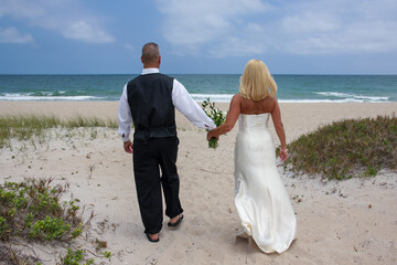 bride and groom walking on the beach