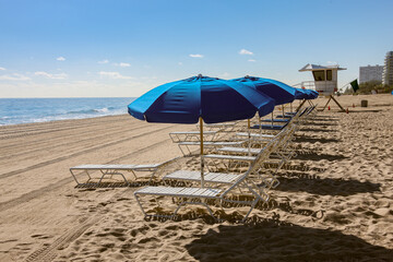  blue beach umbrellas and chairs on the beach
