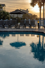 Fototapeta na wymiar swimming pool at evening showing reflection of tree and umbrella 