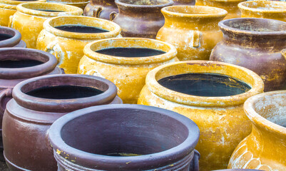 rows of large colorful distressed Mexican clay pottery
