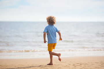 Kids play on tropical beach. Sand and water toy.