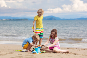 Fototapeta na wymiar Kids play on tropical beach. Sand and water toy.