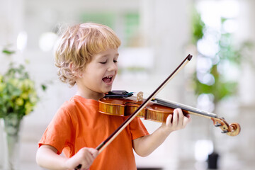 Child playing violin. Remote learning.