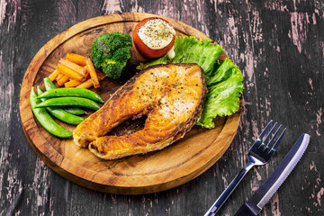 Salmon steak on wooden plate
