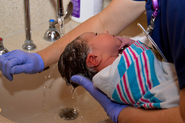 Newborn baby getting his first bath