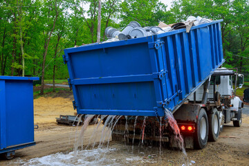 Truck loading a full recycling used construction material in the new building work site.