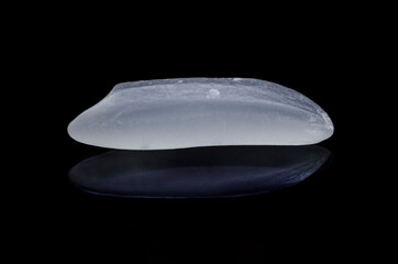 1 grains of uncooked rice, isolated on a black background. Extreme close-up.