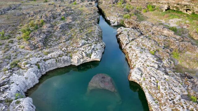 Narrow mountain river flowing through rocky landscape. Stream bed cut deep into rock. Upstream of Cijevna (Cem) in Montenegro. Aerial footage.
