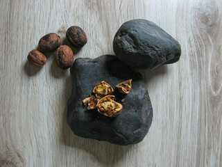 Walnuts broken kernels on the stone next to whole walnuts on wooden background. Close