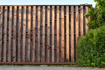 Fragment of dark red grunge wooden entrance gate to the house. Copy space. 