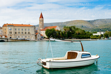 It's Cathedral of St. Lawrence a Roman Catholic triple-naved basilica constructed in Romanesque-Gothic in Trogir, Croatia. UNESCO World heritage. And a boat on the Adriatic Sea