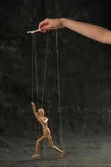 Puppet in the hands of puppeteer walks on isolated, background. The concept of manipulation. Copy space.
