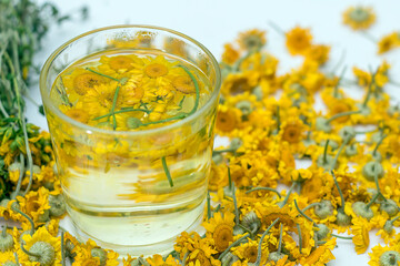 Herbal chamomile tea in a transparent glass.
