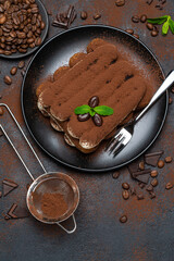 Classic tiramisu dessert on ceramic plate on concrete background