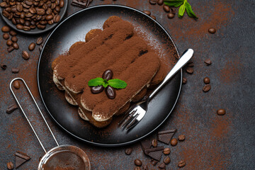 Classic tiramisu dessert on ceramic plate on concrete background