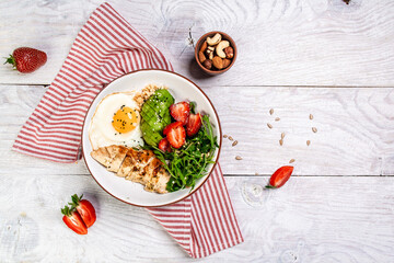 Plate with a keto diet food, Chicken salad with arugula and strawberries. Top view