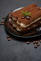 Classic tiramisu dessert on ceramic plate on concrete background