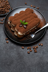 Classic tiramisu dessert on ceramic plate on concrete background