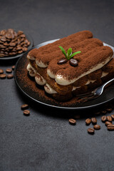 Classic tiramisu dessert on ceramic plate on concrete background