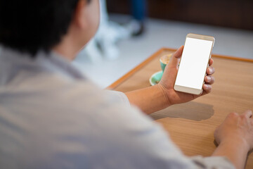 man using mobile phone in living room.