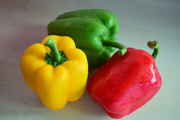 red yellow and green peppers on a wooden floor