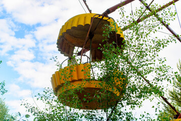 Observation wheel carousel with yellow cabins in the former musement park in Pripyat, a ghost town in northern Ukraine, evacuated the day after the Chernobyl disaster on April 26, 1986