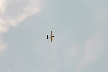 Light aircraft in sunlight on clear blue sky.