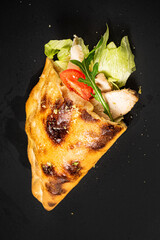 calzone pizza on the black background