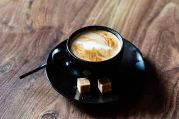 cup of cappuccino on the wooden background