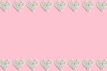 frame made hearts of white hydrangea flowers on a pink background. flat lay, top view, space for a text