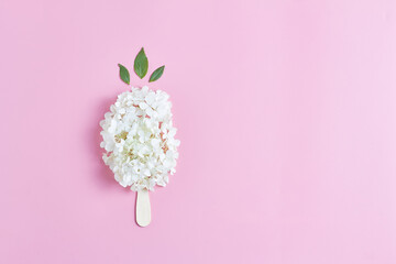 floral ice cream. white fresh hydrangea flowers on a pink background. flat lay, top view, space for...