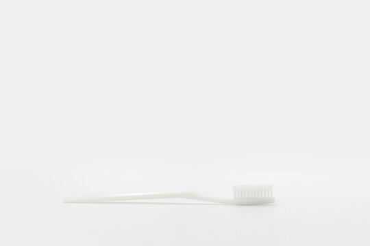 Isolated simple normal white toothbrush is laid on the white background in studio light. Clipping Path.