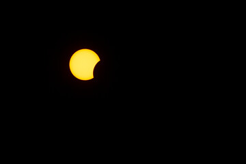 The moon covers the sun in partial solar Eclipse in the dark sky