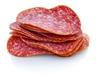 Slices of dry salame. Small heap of sausage slices. Cutted salami on white bg. Isolated on white background with shadow reflection. With clipping (vector) path. Italian sausage on reflective underlay.