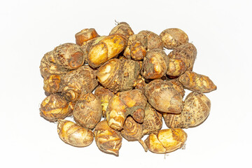 Fresh harvested organic taro corms,satoimo potatoes or taro roots on white background.