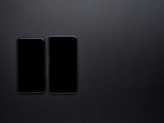 Black smartphone on black background.