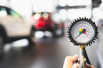 inspection Measure quantity Inflated Rubber tires car Close up hand holding machine Inflated...