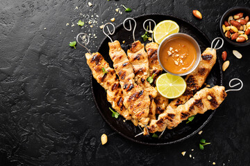 Grilled chicken satay skewers with peanut butter sauce.