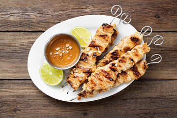 Grilled chicken satay skewers with peanut butter sauce.