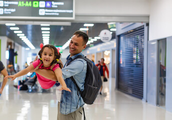 Lets find our flight. view of happy father and daughter at the airport in terminal