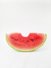 Juicy bright part of a red watermelon on a white background. A bit of watermelon. The trail from the teeth.