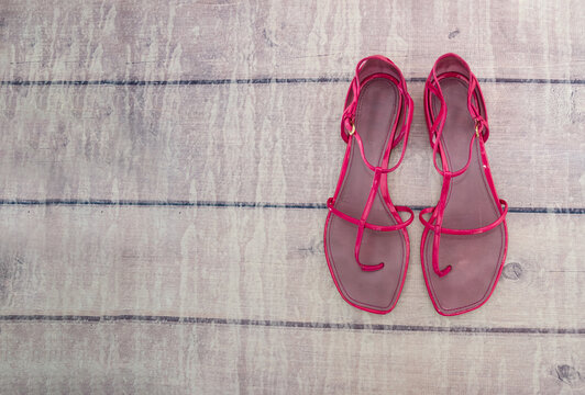 Women's summer sandals on a wooden background. Pink sandals. Copy of space. Place for text.