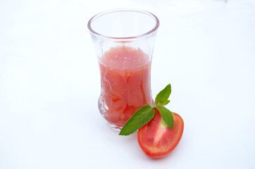 tomato juice in glass with half cutt tometo and green mint